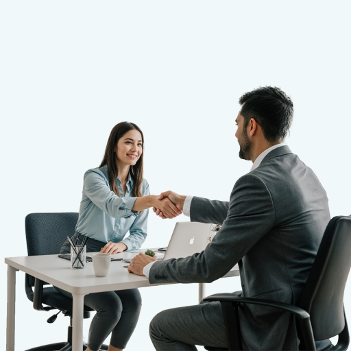Duas pessoas sentadas e dandos as mãos como quem fecha um acordo